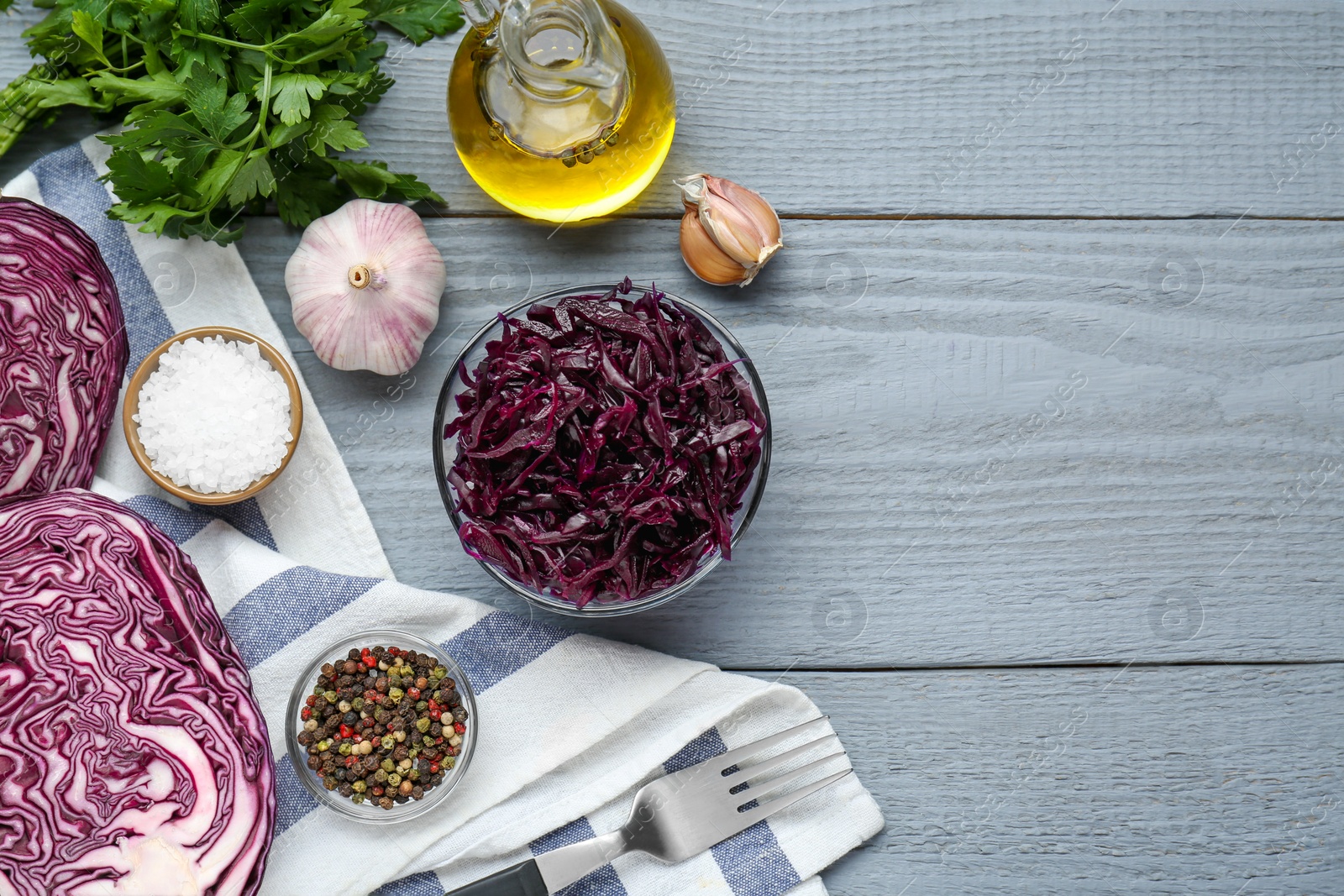 Photo of Tasty red cabbage sauerkraut and different ingredients on light grey table, flat lay. Space for text