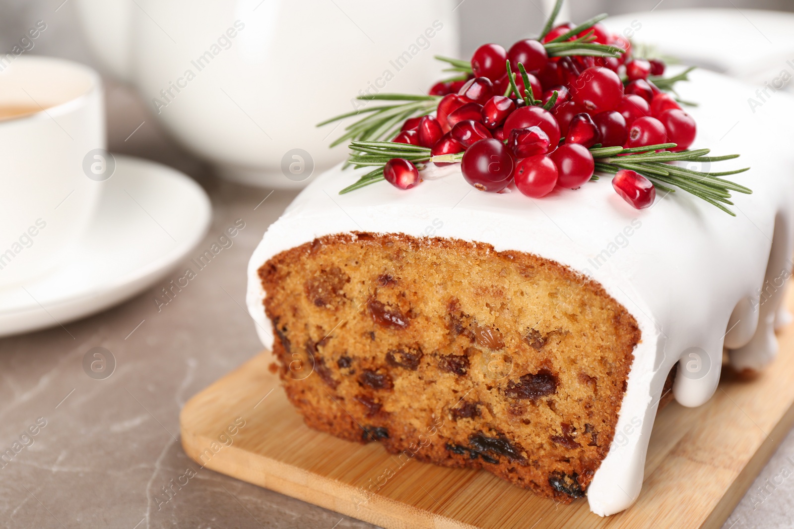 Photo of Traditional classic Christmas cake decorated with cranberries, pomegranate seeds and rosemary on table, closeup