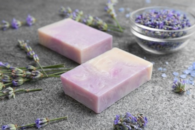 Photo of Hand made soap bars with lavender flowers on grey stone table