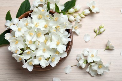 Photo of Beautiful jasmine flowers on white wooden table, flat lay