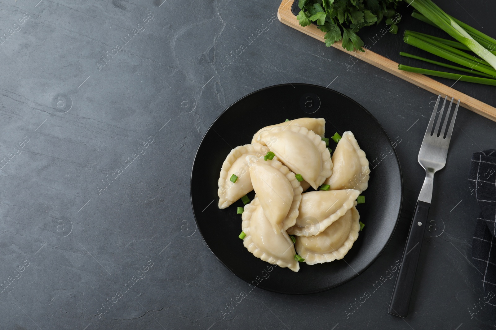 Photo of Flat lay composition with tasty dumplings served on grey table. Space for text