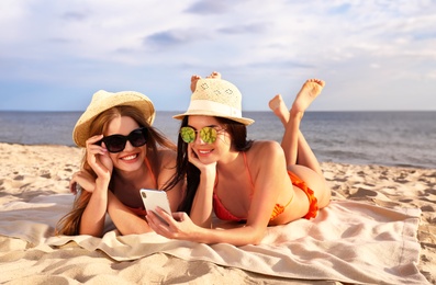 Photo of Young couple in bikini spending time together on beach