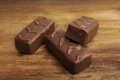 Delicious chocolate bars on wooden table, closeup