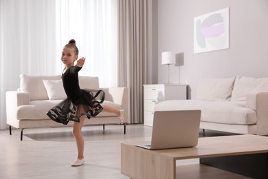 Cute little girl taking online dance class at home