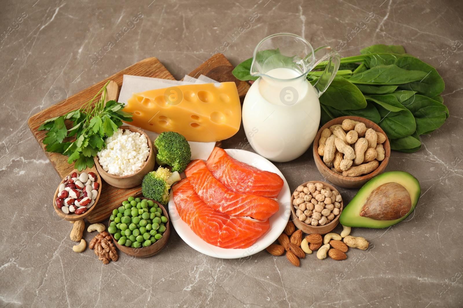 Photo of Different products rich in protein on marble table