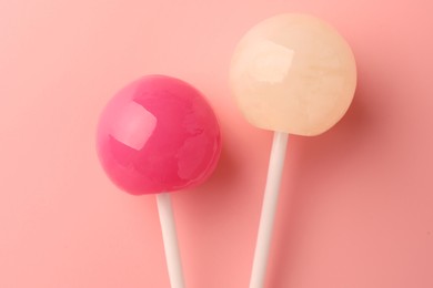 Tasty lollipops on pink background, flat lay