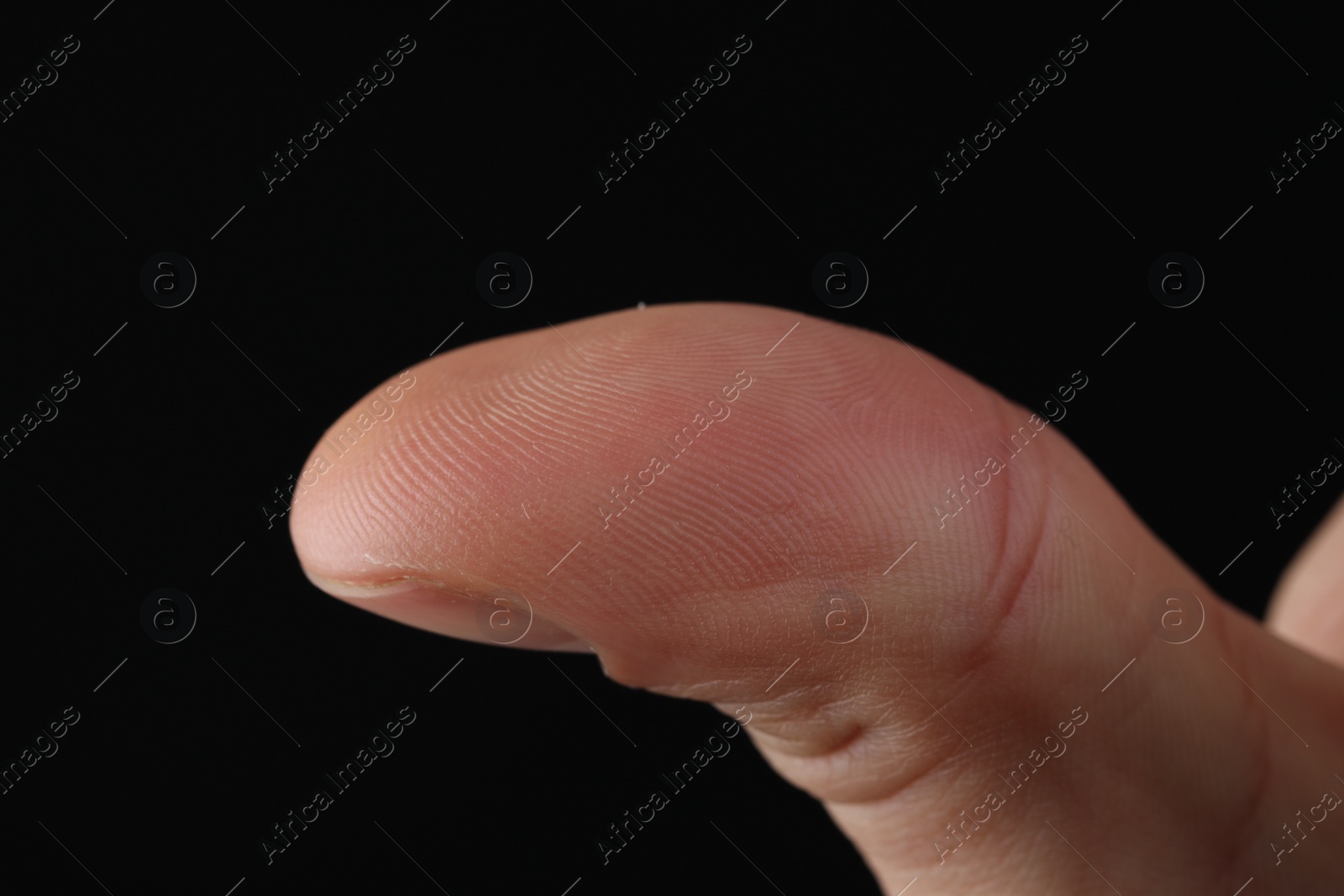 Photo of Man scanning fingerprint on black background, closeup