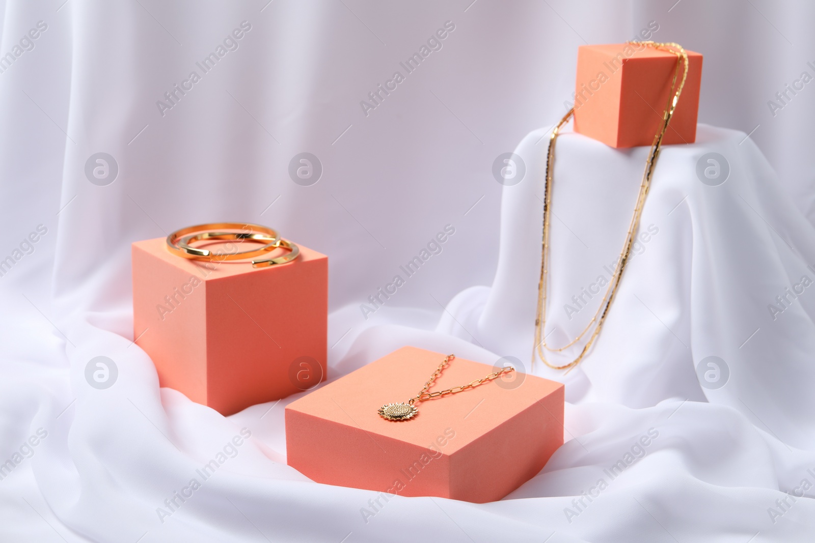 Photo of Stylish presentation of bracelets and necklaces on white cloth