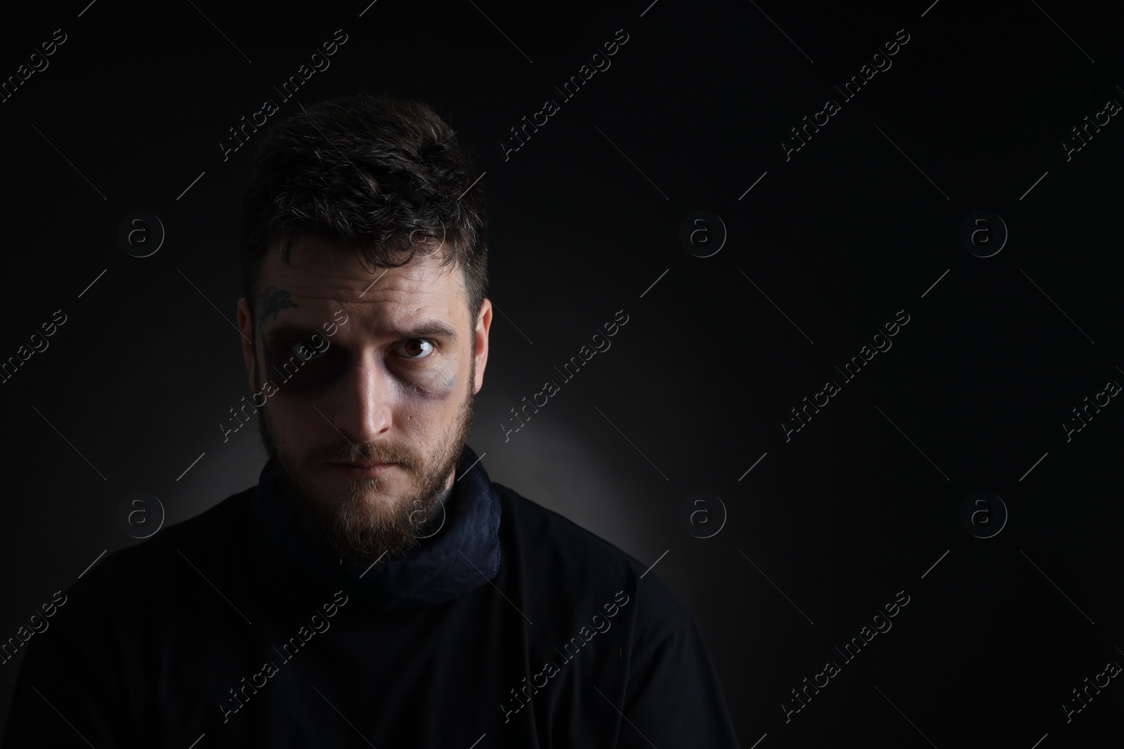 Photo of Man with bruise on dark background, space for text. Hostage