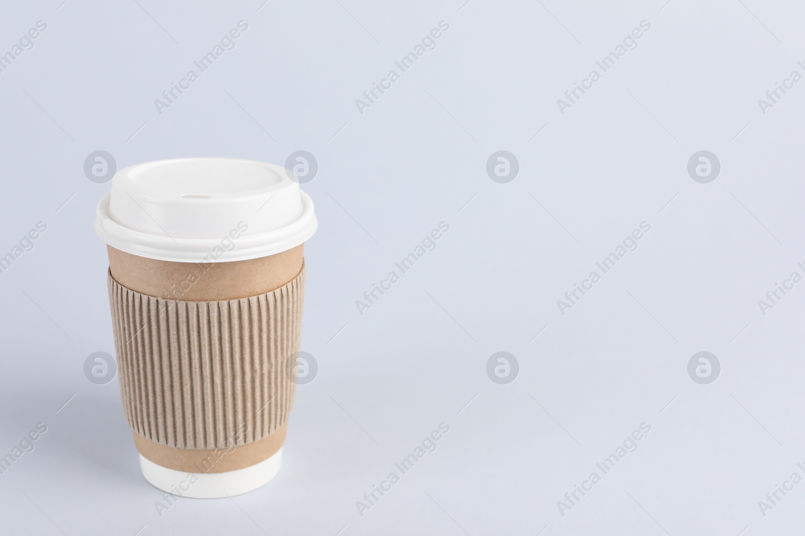 Photo of Paper cup with plastic lid on light background, space for text. Coffee to go