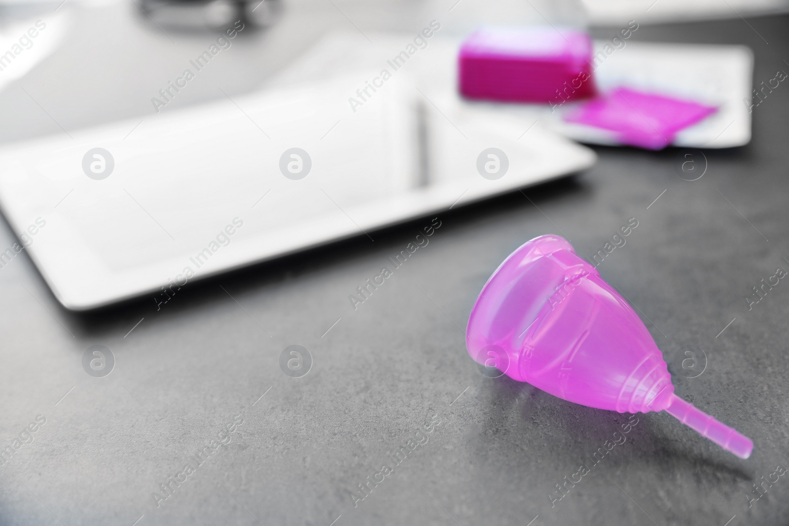 Photo of Menstrual cup on grey table. Gynecological care