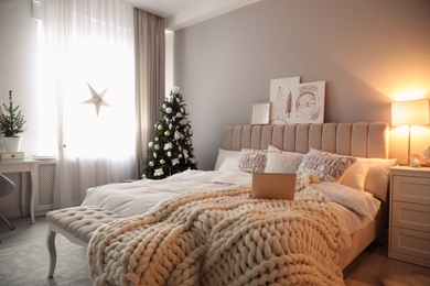 Beautiful decorated Christmas tree in bedroom interior