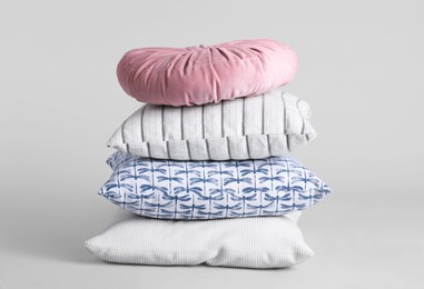 Stack of stylish soft pillows on grey background