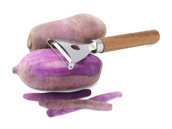 Photo of Ripe purple daikon radishes and peeler isolated on white