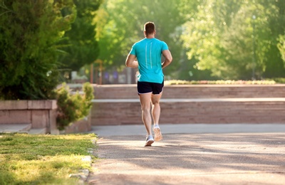 Photo of Young man running in park on sunny day