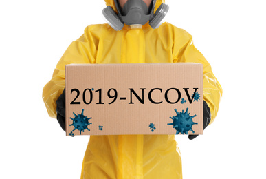 Image of Man wearing chemical protective suit with cardboard box on white background, closeup. Coronavirus outbreak