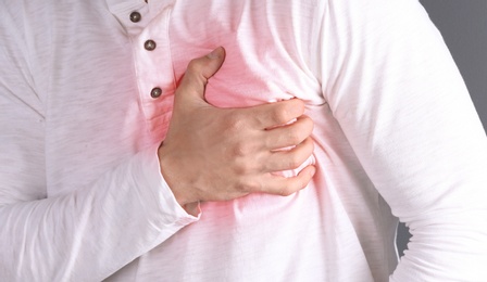 Photo of Young man having heart attack, closeup