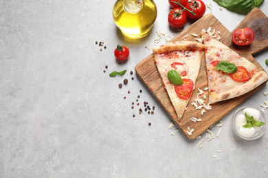 Photo of Slices of delicious pizza Margherita on light grey table, flat lay. Space for text