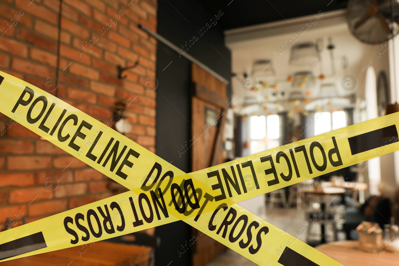 Image of Yellow crime scene tape in empty restaurant