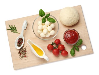 Photo of Wooden board with raw dough and other ingredients for pizza on white background, top view