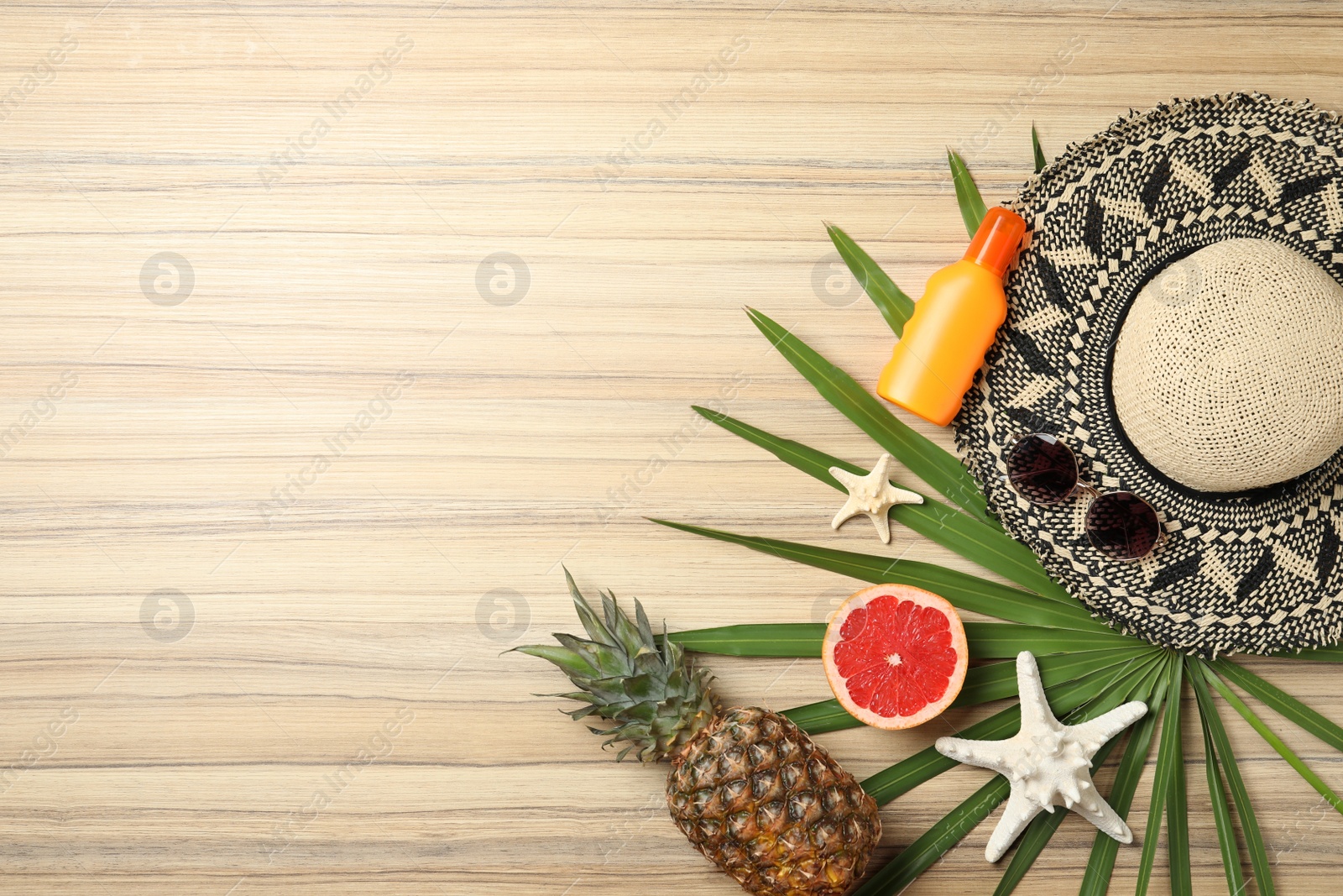 Photo of Flat lay composition with fruits and beach objects on wooden background. Space for text