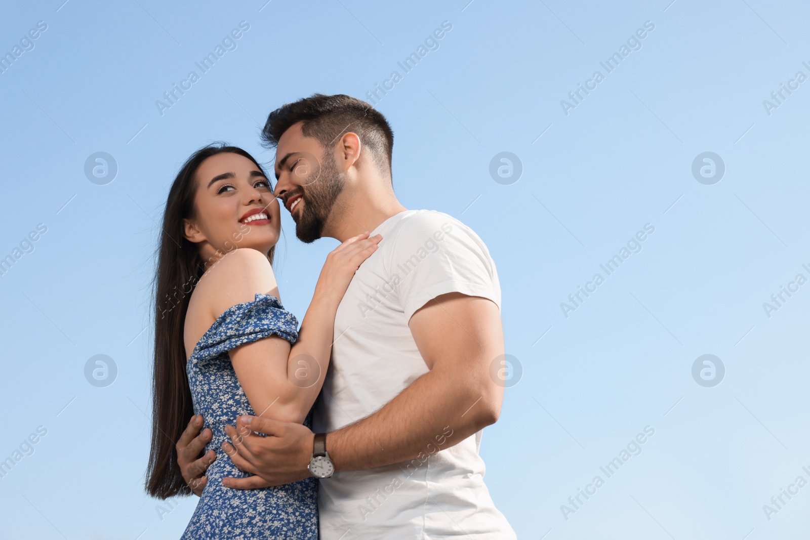 Photo of Romantic date. Beautiful couple spending time together against blue sky, low angle view with space for text