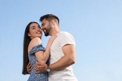 Romantic date. Beautiful couple spending time together against blue sky, low angle view with space for text