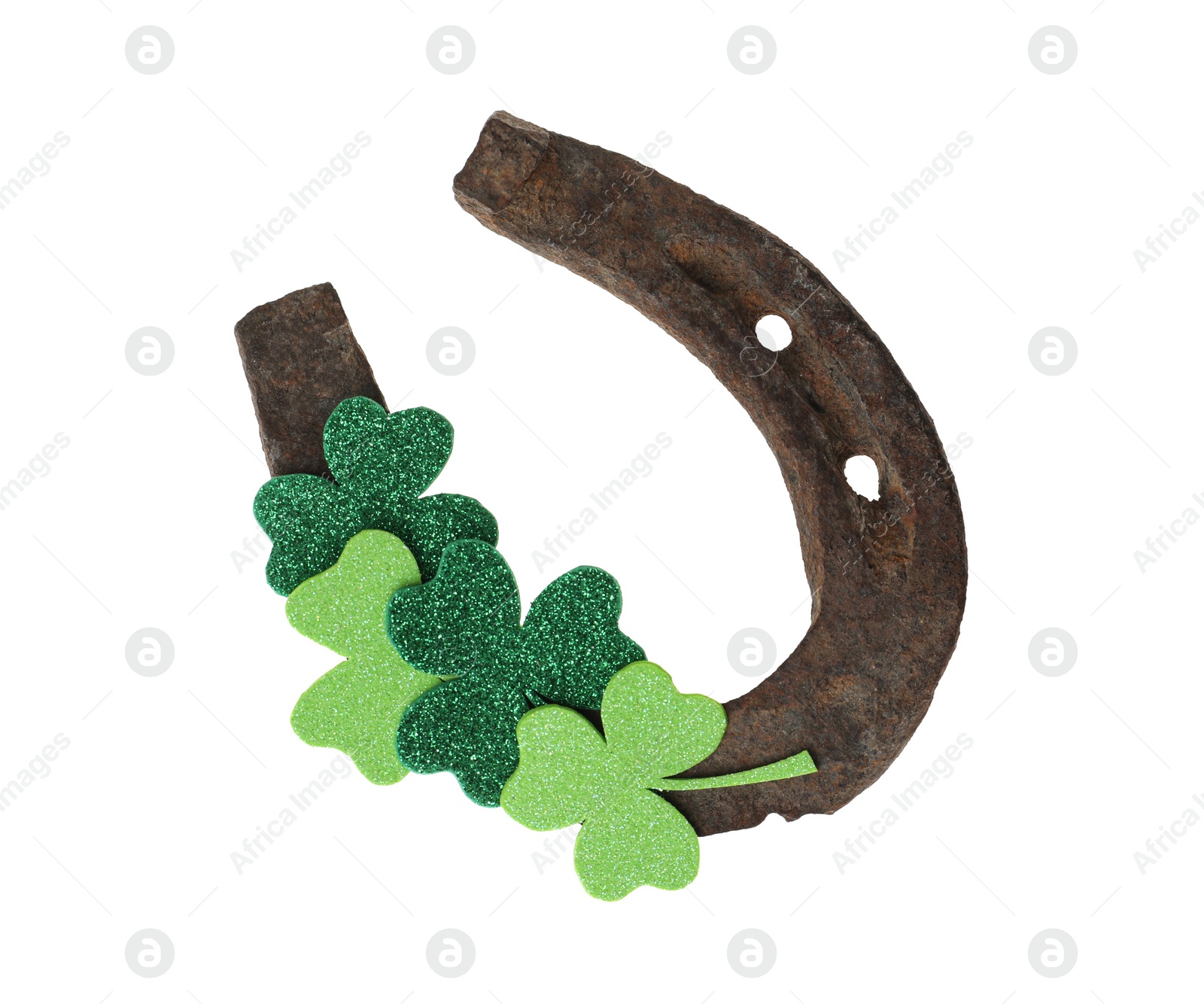 Photo of Old horseshoe and clover on white background. St. Patrick's Day celebration