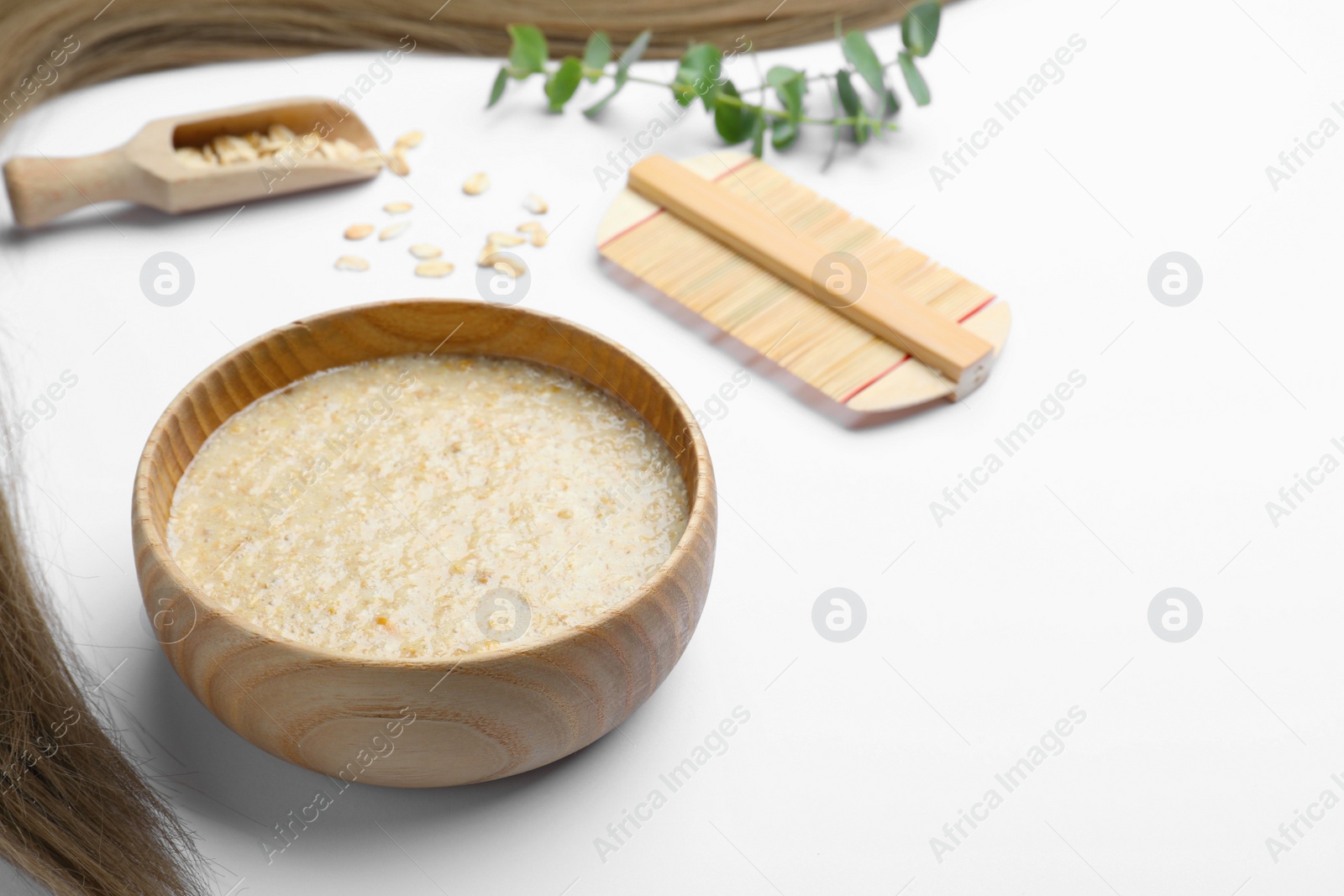 Photo of Homemade hair mask, oatmeal and comb on white background, space for text