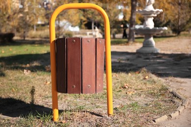 Wooden trash bin in park on sunny day