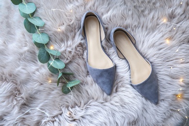 Photo of Elegant female shoes on fluffy carpet