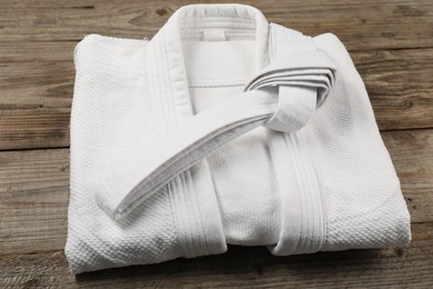 White karate belt and kimono on wooden background