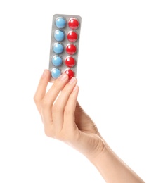 Woman holding pills in blister pack on white background, closeup