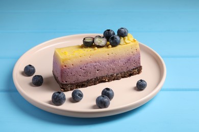 Photo of Delicious cheesecake with blueberry on light blue wooden table, closeup