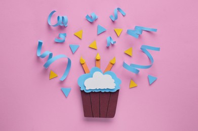 Photo of Paper cupcake and confetti on pink background, flat lay