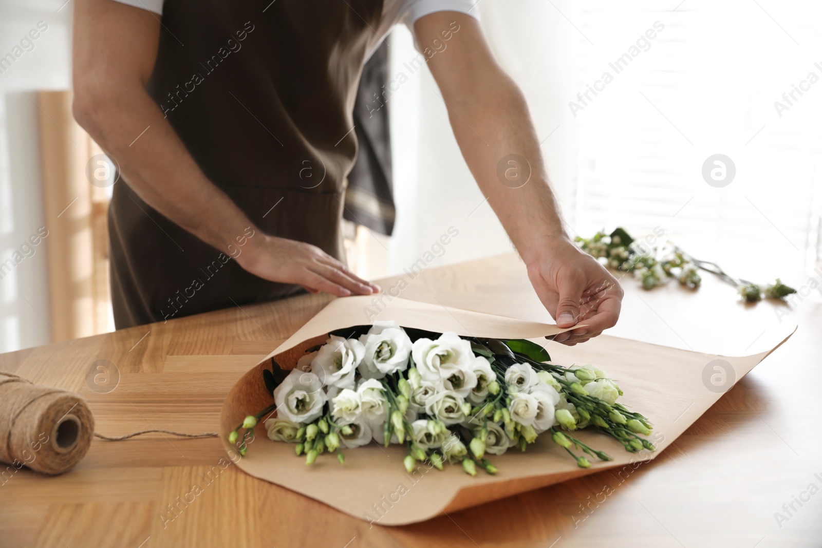 Photo of Florist making beautiful bouquet in workshop, closeup