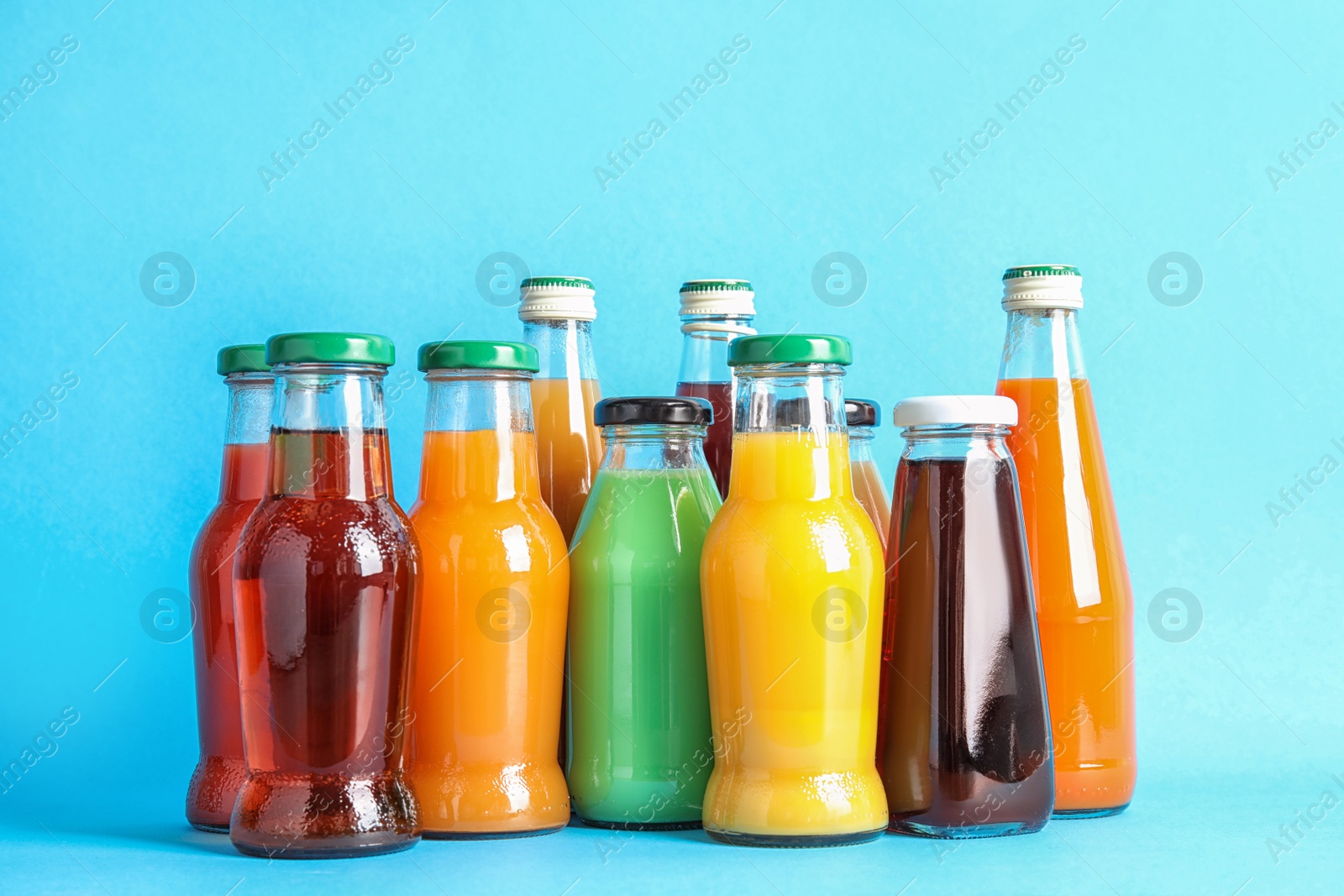 Photo of Bottles with different juices on color background