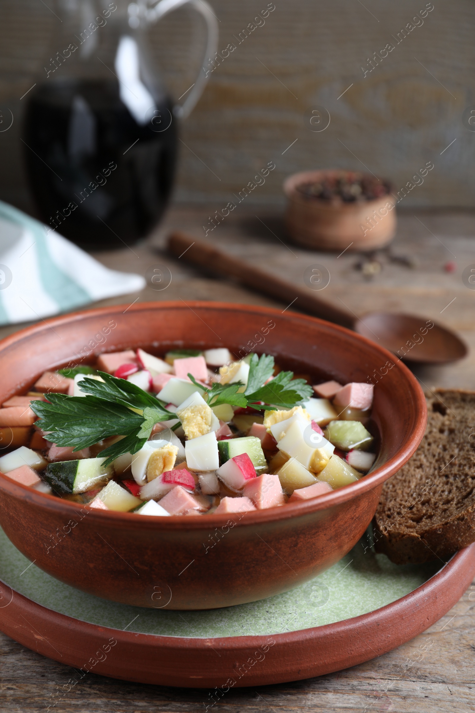Photo of Delicious cold okroshka with kvass served on wooden table. Traditional Russian summer soup
