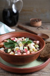 Photo of Delicious cold okroshka with kvass served on wooden table. Traditional Russian summer soup