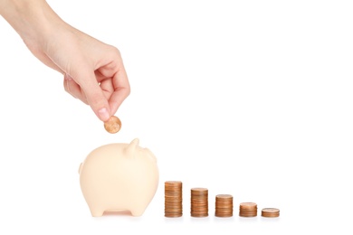 Photo of Woman putting coin into piggy bank on white background. Space for text