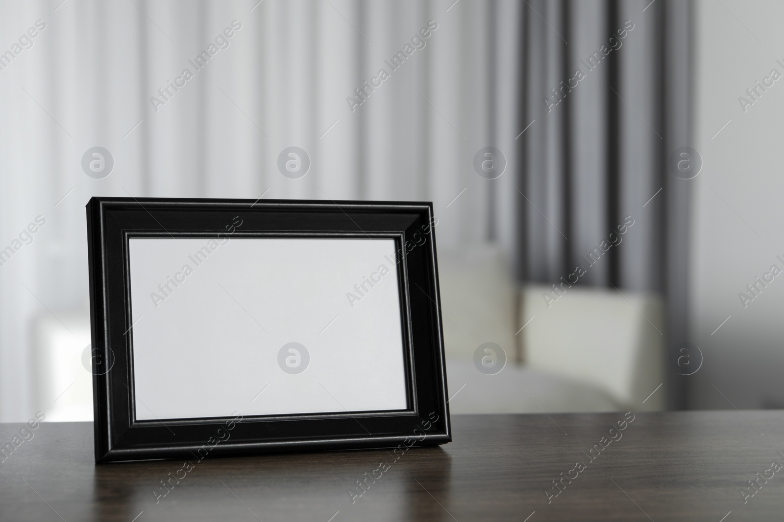 Photo of Empty square frame on wooden table indoors, space for text