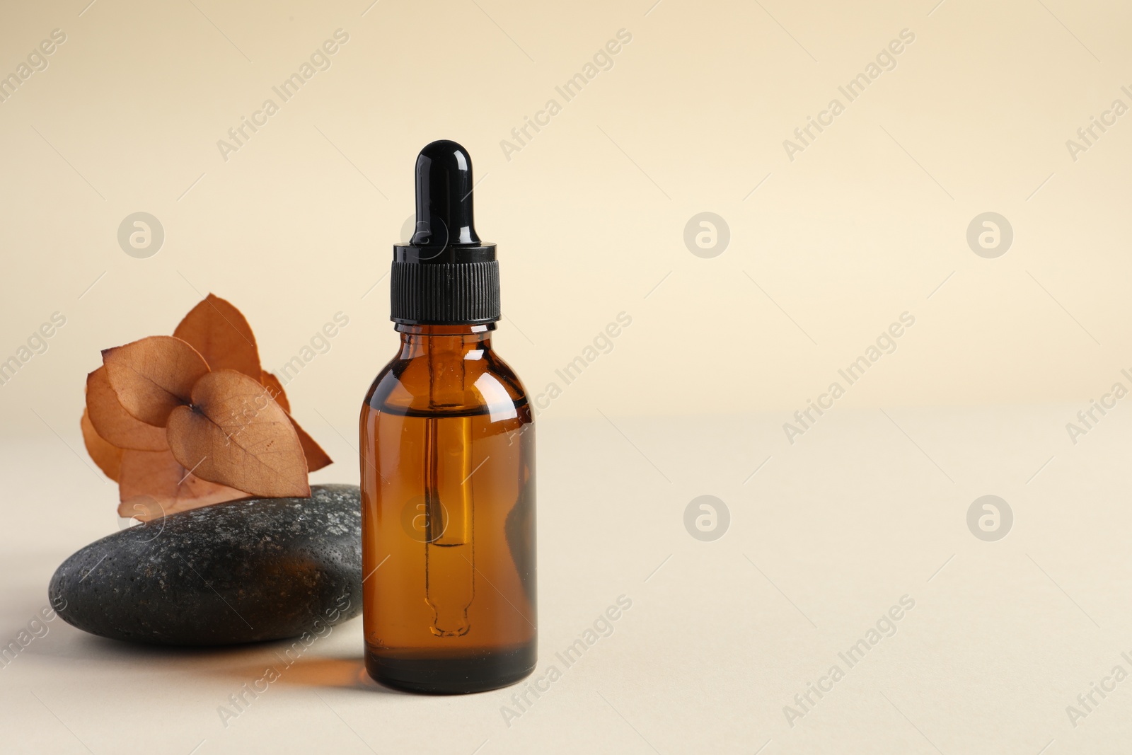 Photo of Composition with bottle of cosmetic serum on beige background. Space for text