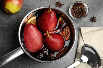 Poaching pears in mulled wine on grey table, flat lay