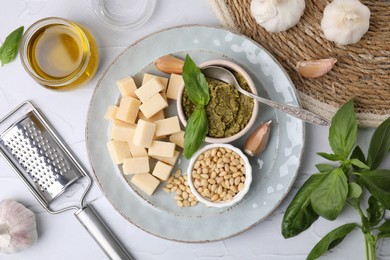 Tasty pesto sauce and ingredients on white textured table, flat lay