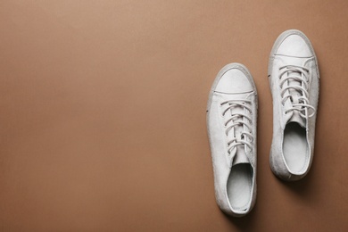 Stylish sneakers on color background, top view with space for text