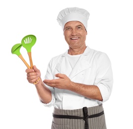Mature male chef holding ladle and slotted spoon on white background