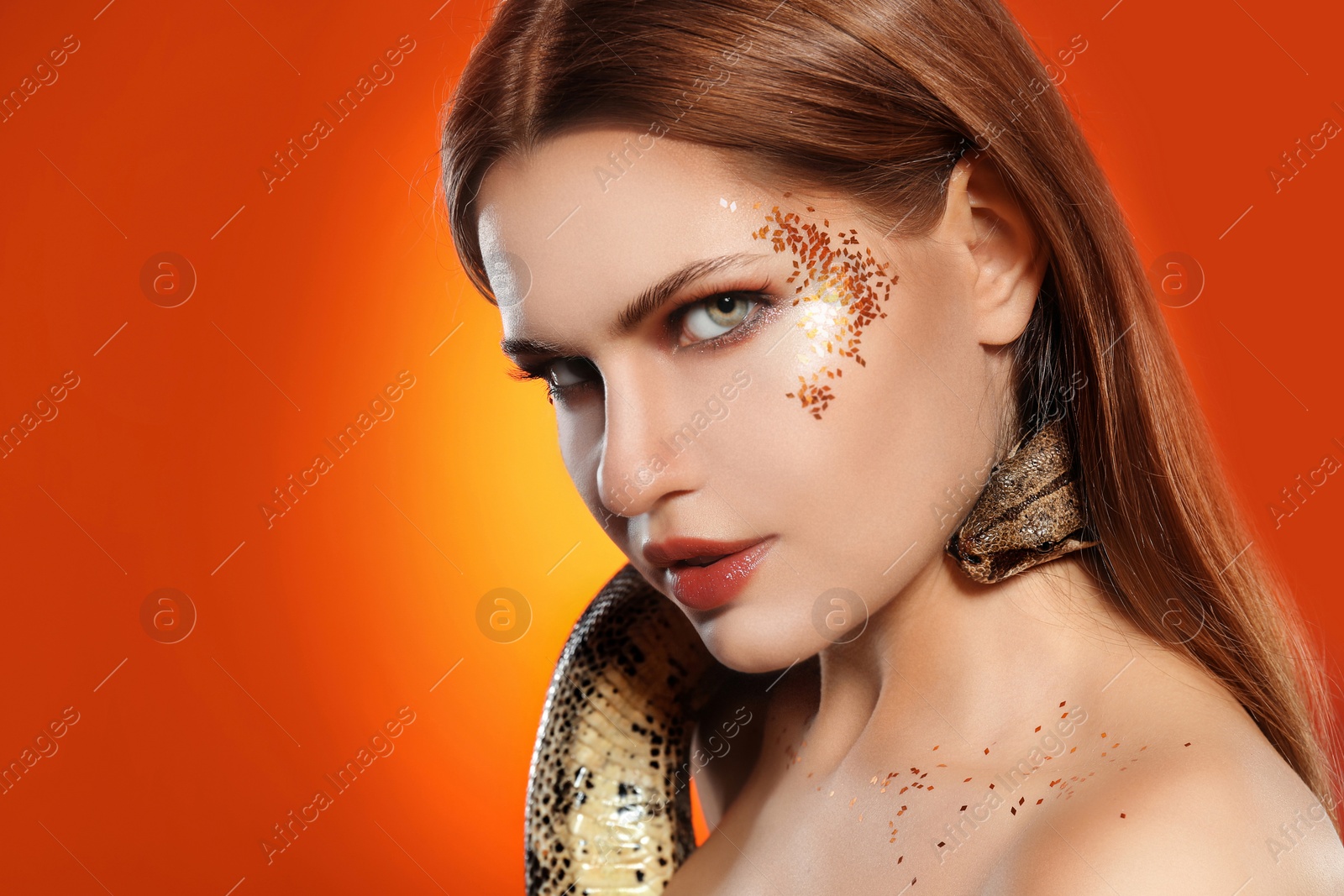 Photo of Beautiful woman with boa constrictor on bright colorful  background, closeup