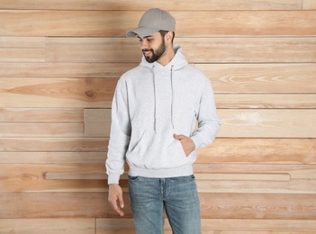 Portrait of young man in sweater at wooden wall. Mock up for design