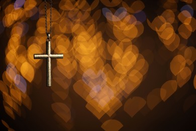 Photo of Wooden cross against blurred lights, closeup with space for text. Religion of Christianity