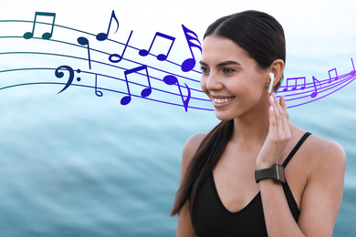 Image of Young sportswoman listening to music with wireless earphones near river